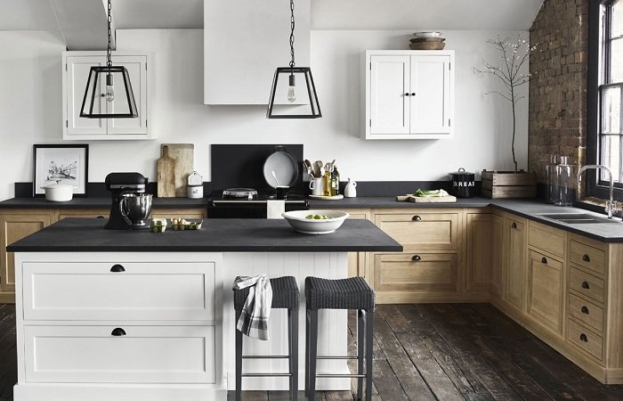 A white and black kitchen with wooden floors in a home interior.