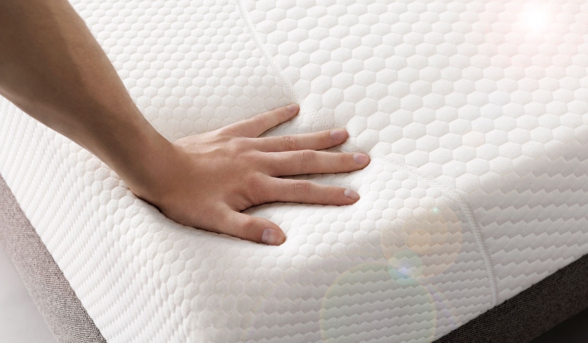 A person's hand is touching the top of a perfect mattress.