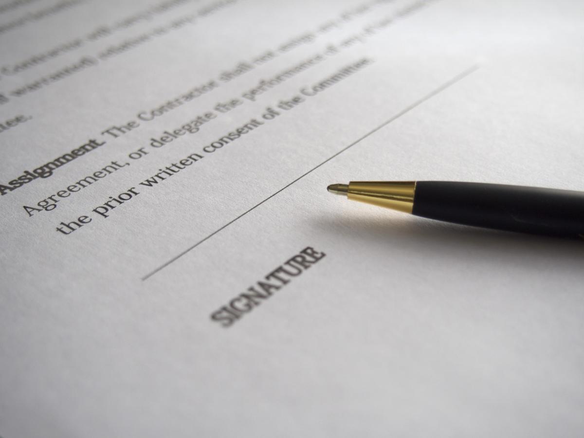 A notarized document has a pen on top.
