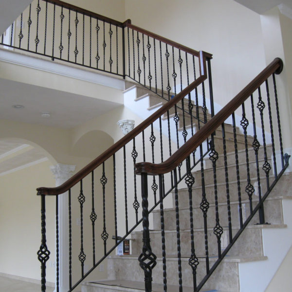 A staircase with elegant wrought iron handrail designs.