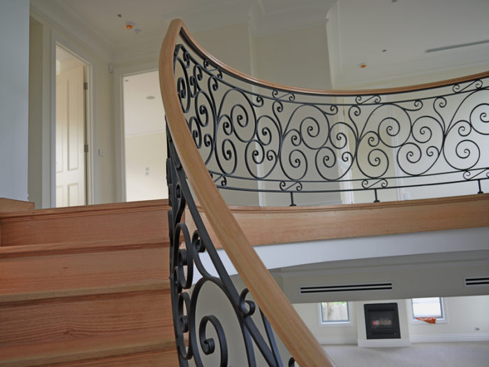 A house staircase with wrought iron handrail designs.