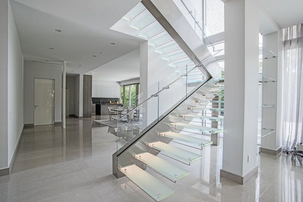 A glass staircase with modern handrail designs in a home.
