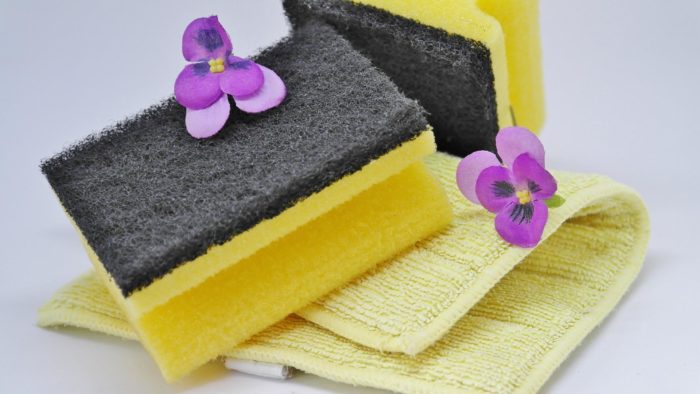 A set of yellow and black sponges for green cleaning.