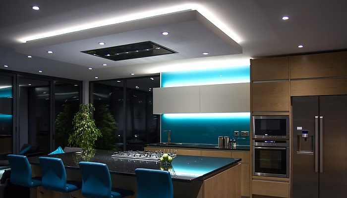 A modern home design with blue lighting and blue chairs.