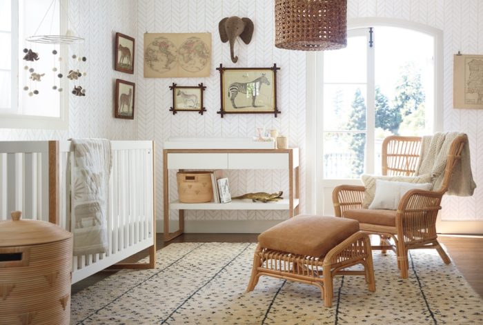 Nursery design with a wicker chair and a rug.