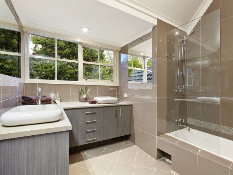 An upgraded bathroom with a glass shower and sink.