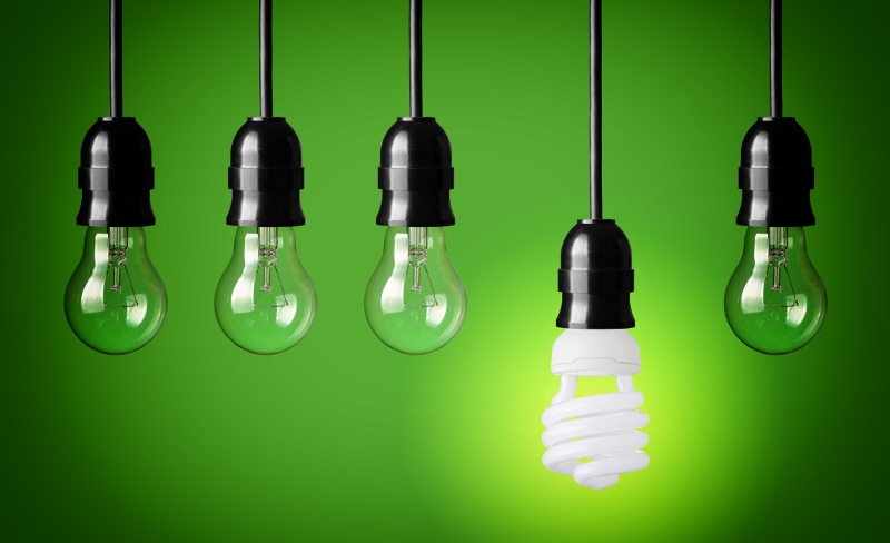 A group of energy-saving light bulbs on a green background.