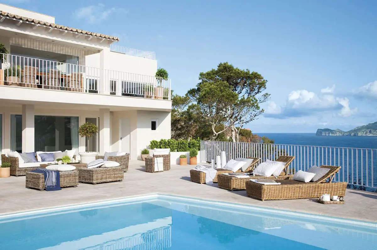 Luxury seaside villa with pool and lounge area.