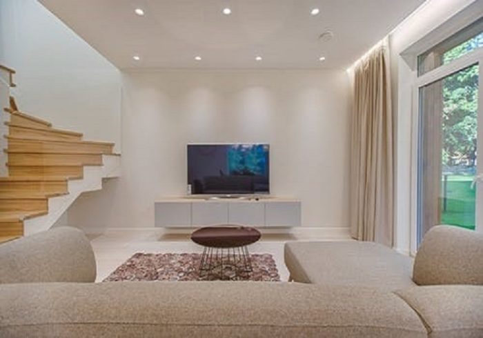 A modern interior with a TV and stairs.