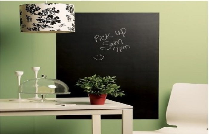 A black chalkboard on a wall in a dining kitchen.