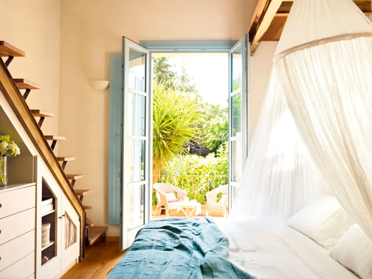 A bedroom in a house with a bed and a mosquito net.