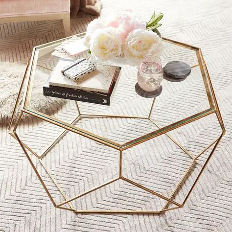 A stunning gold coffee table adorned with flowers and books.
