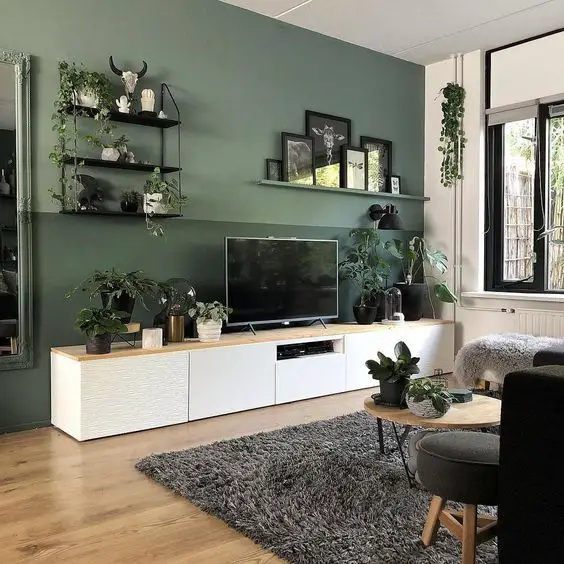 A living room with green walls and a TV, perfect for an inspirational space.