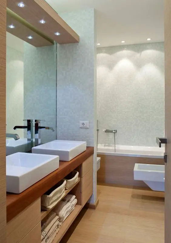 A modern bathroom with two sinks and a small bathtub.