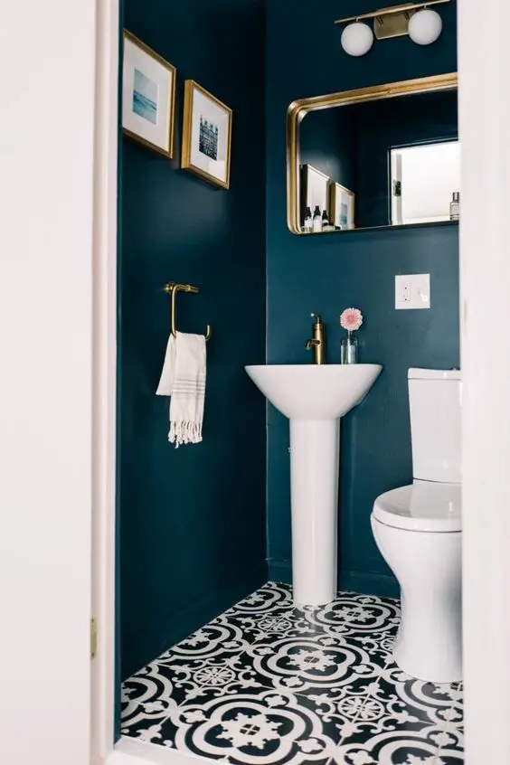 A small bathroom with a black and white tiled floor.