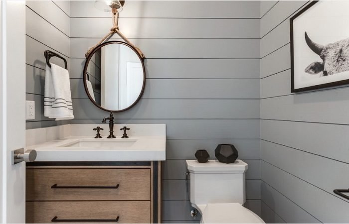 A gray bathroom with a wooden vanity.