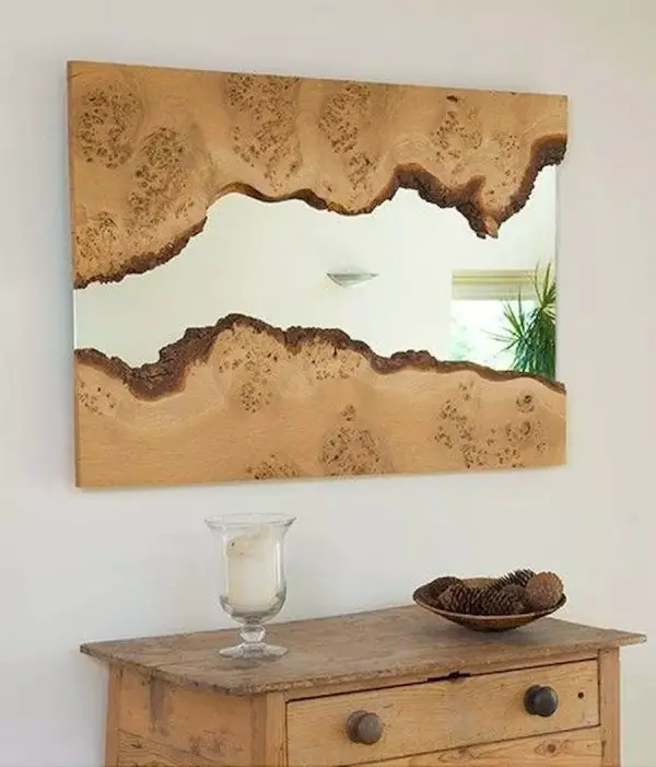 A tree stump mirror is hanging on a wall.
