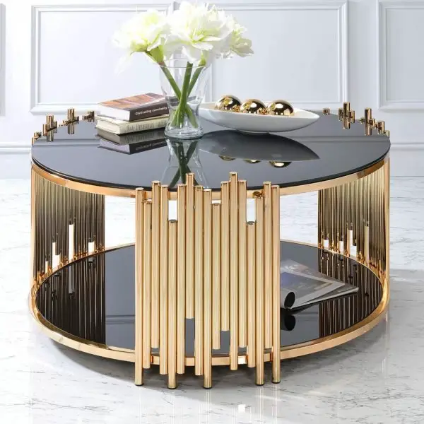 Elegant round gold and black coffee table with decor.