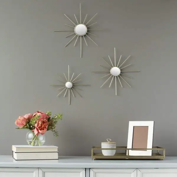 Three metal sunburst wall art on a gray wall, perfect for mirror ideas.