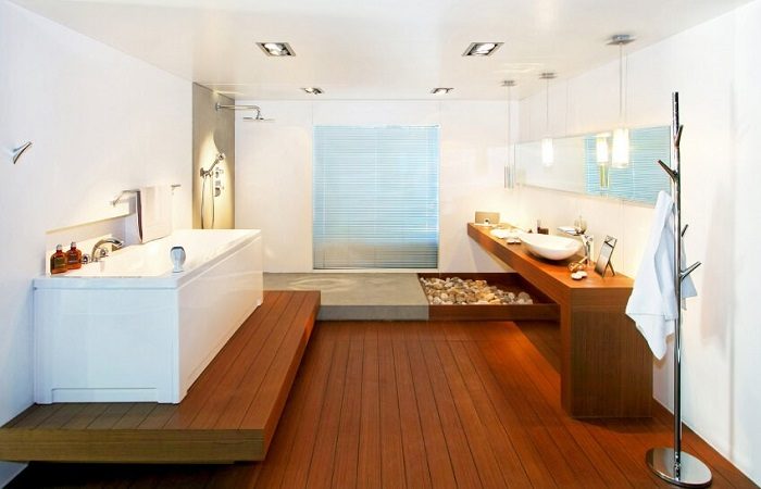 A modern bathroom with wooden floors and a sink enhanced by sophisticated lighting.