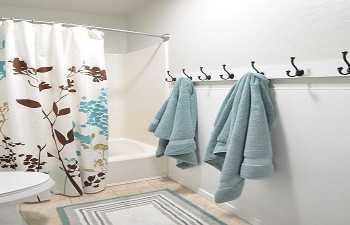 A bathroom with towels and a shower curtain.