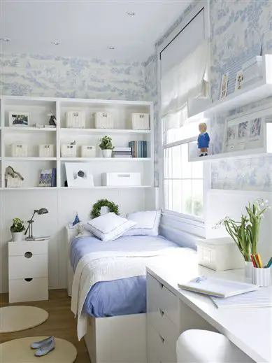 A white and blue kid's room with a bed and a desk.