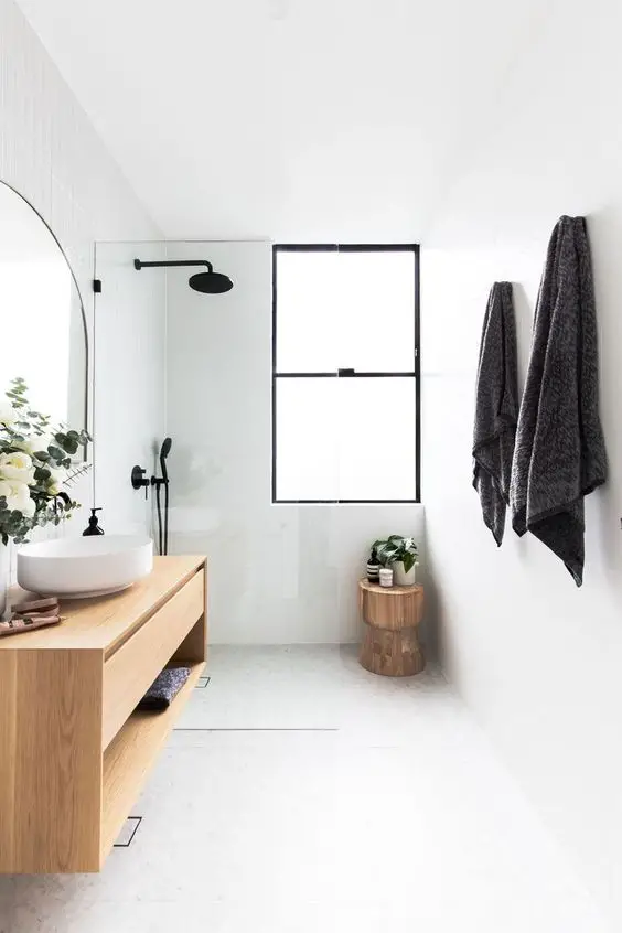 A small white and wood bathroom with a sink and mirror.