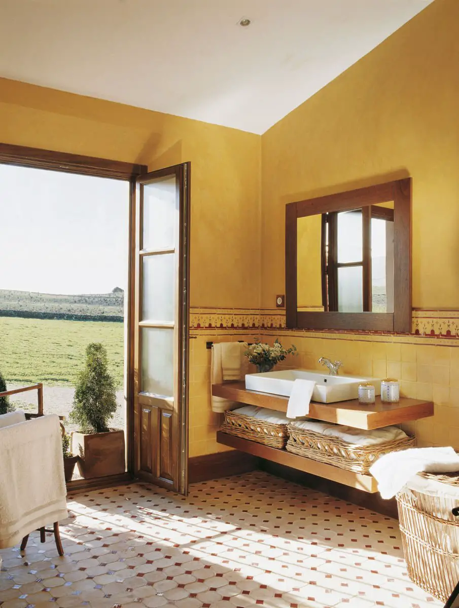 A painted yellow tiled bathroom.