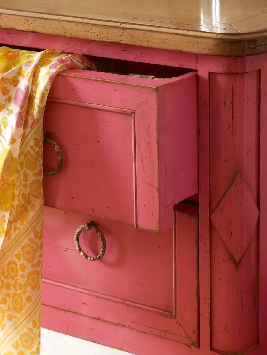 A pink dresser with woodworm infestation.