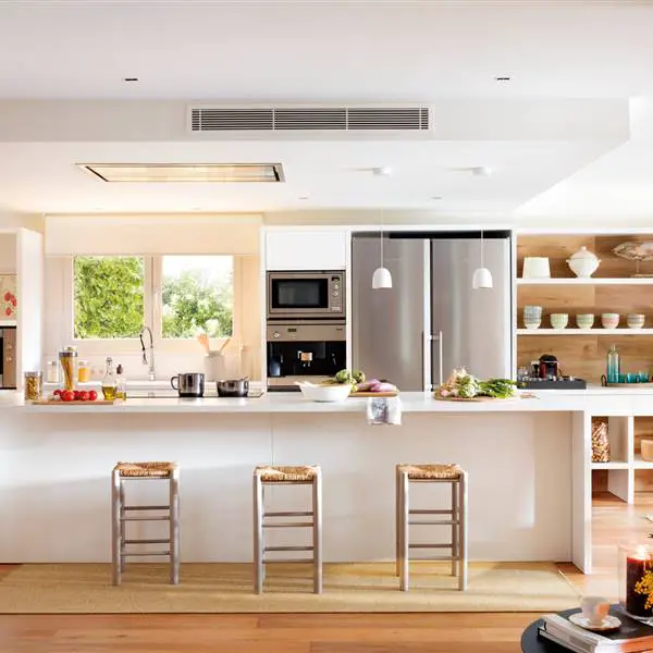 A renovated kitchen featuring wooden floors and stools.