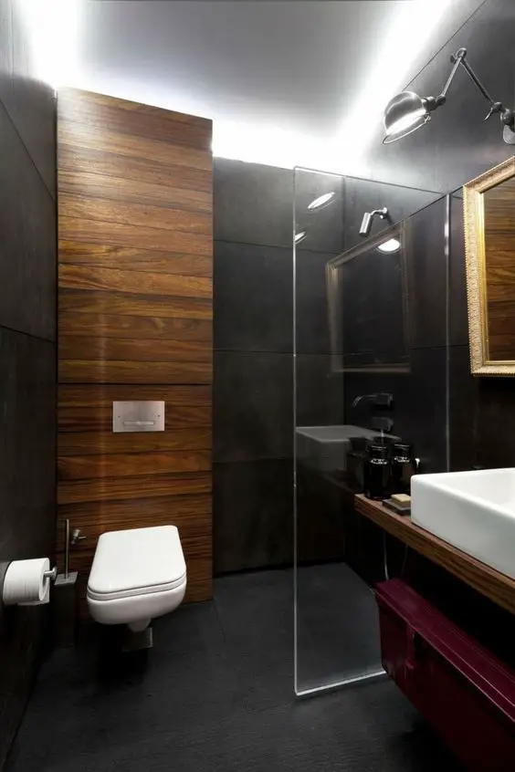 A modern bathroom with wooden accents and small black walls.