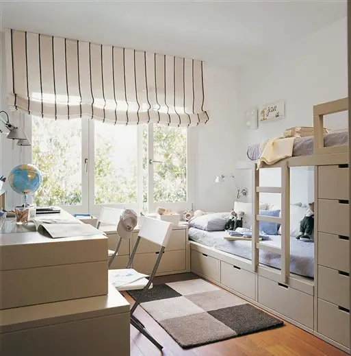 A kid's room with bunk beds and a desk.