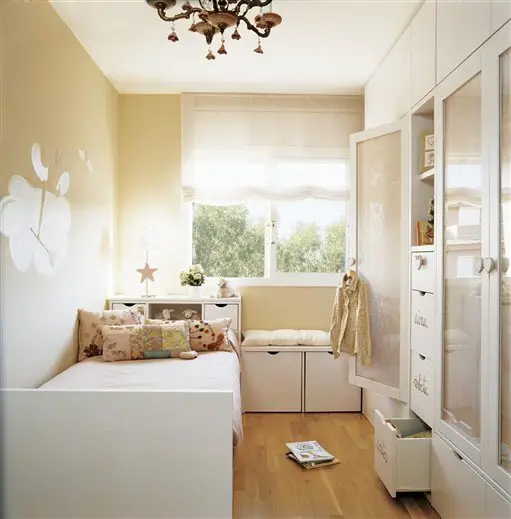 Keywords: small, bedroom

Modified Description: A small kid's bedroom with white cabinets and a bed.