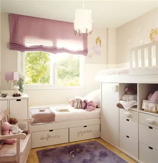 A kid's room with a bunk bed and white furniture.