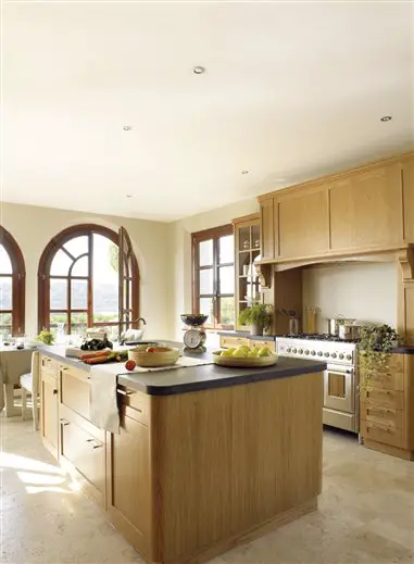 A spacious kitchen with a wooden cabinet and a sizable island showcases an exquisite kitchen design.