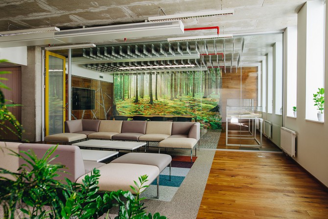 A modern, ergonomic office with large windows and a green wall.