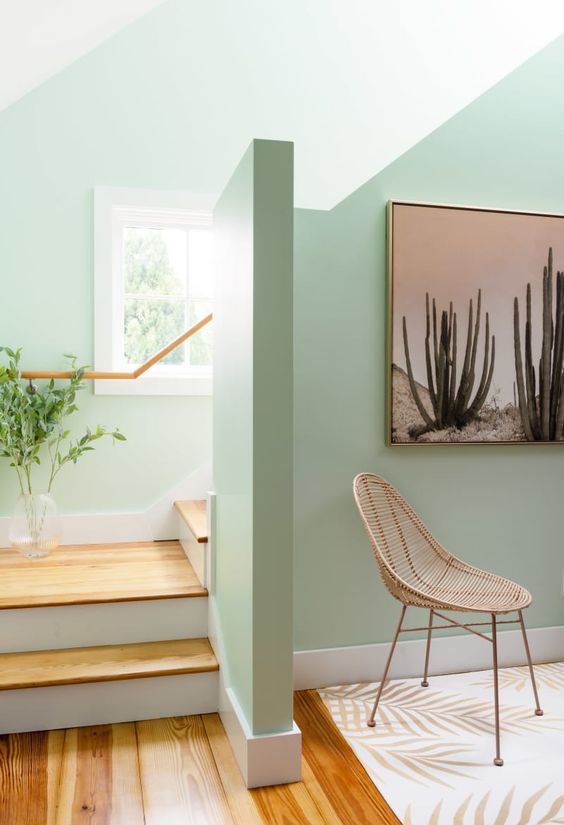 A living room with green walls and a cactus on the wall, perfect for inspirational decor.