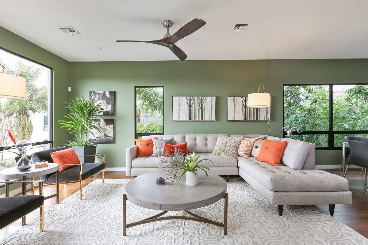 A green living room with a ceiling fan.