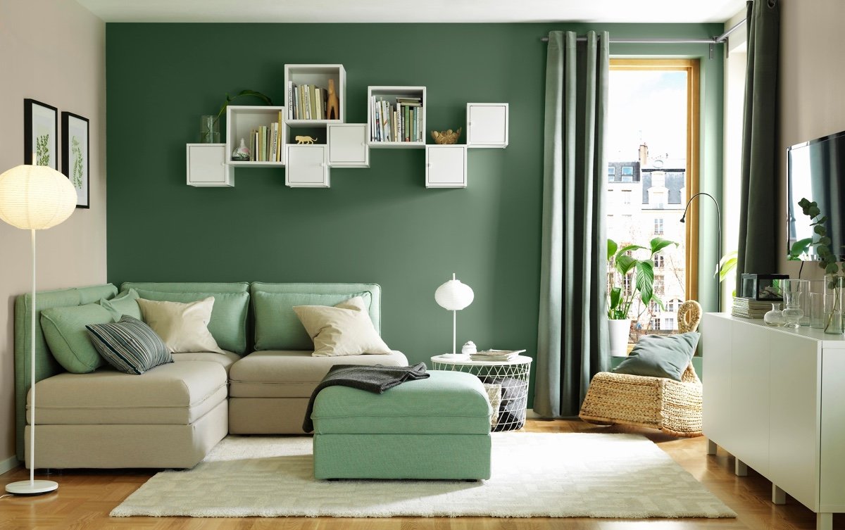 A living room with green walls and white furniture that is inspirational.
