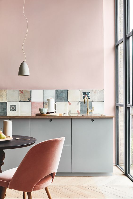 A kitchen featuring pink walls and furniture.