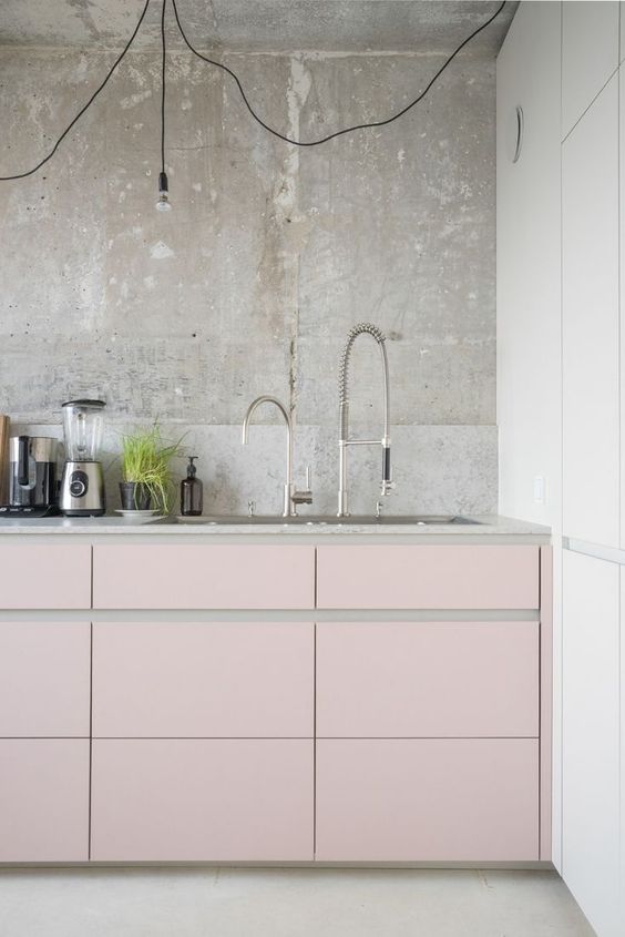 A kitchen with pink cabinets and white counter tops, incorporating pink in the design.