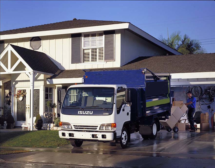 A truck parked in front of a house for rubbish removal.