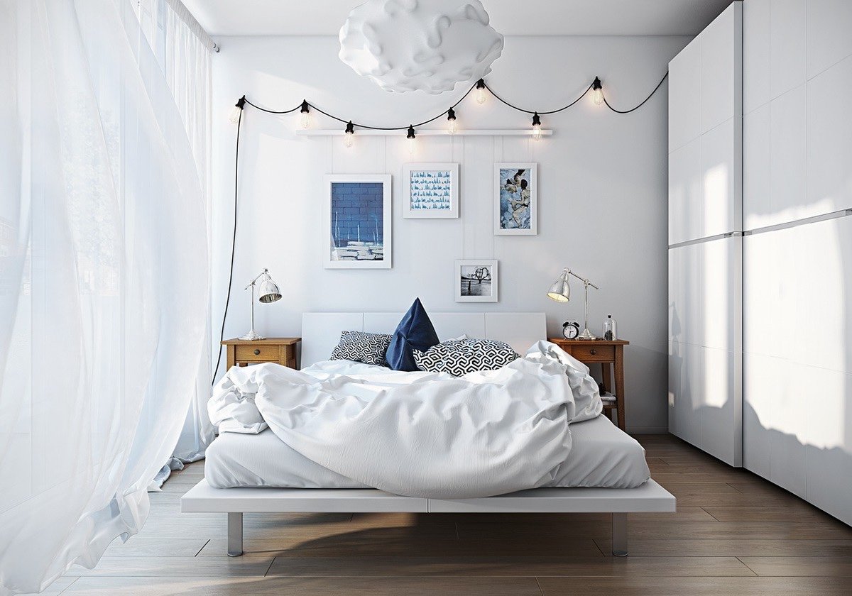 A bedroom with a Scandinavian-inspired white bed and white walls.