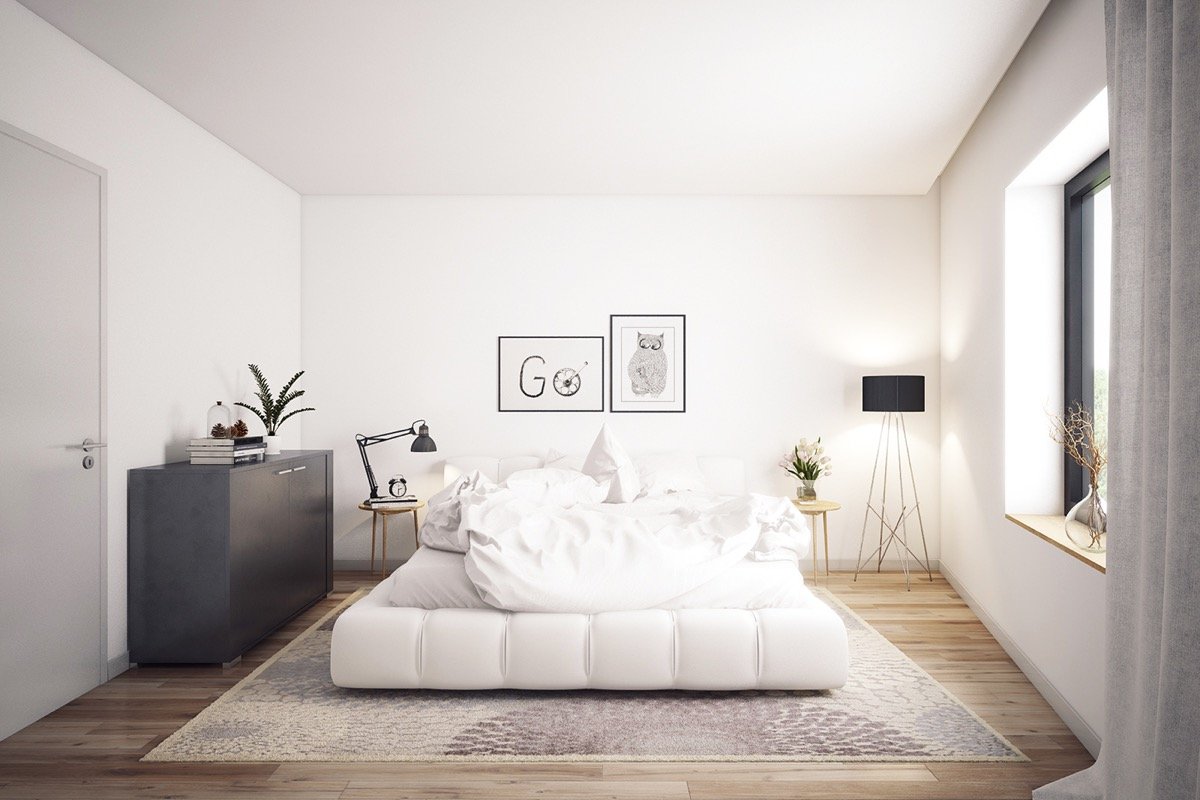 A Scandinavian-inspired white bedroom with wooden floors.