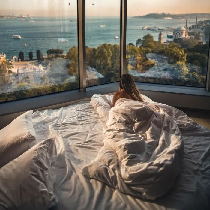A woman enjoying the city view from her bedroom.