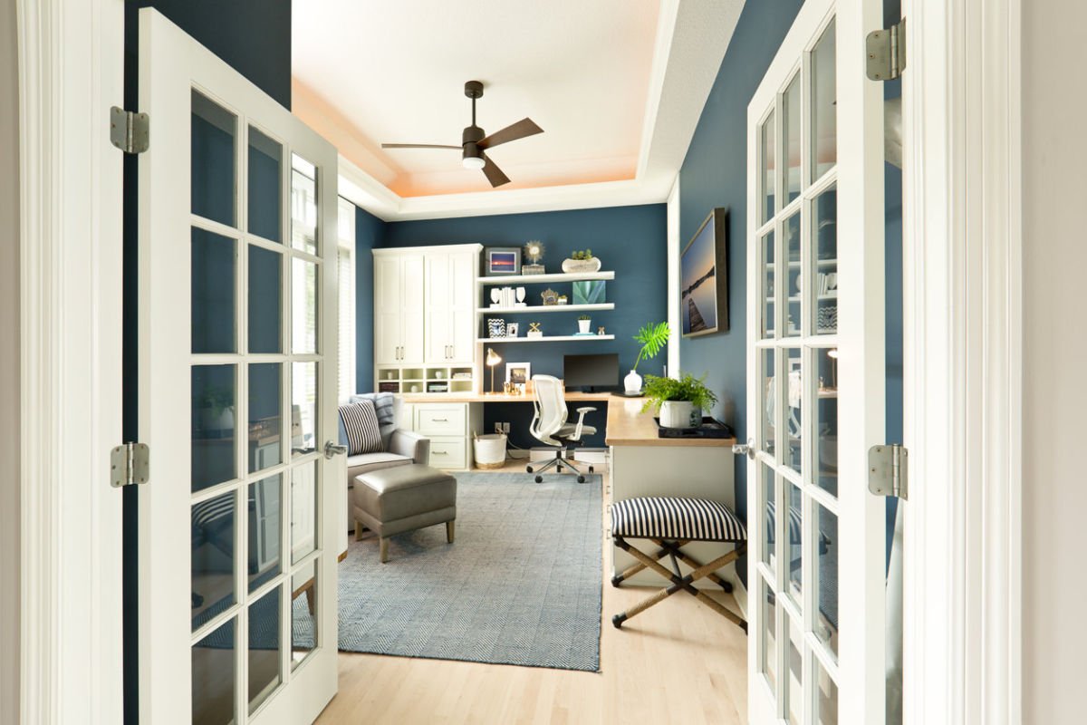 A home office with blue walls and white doors that is inspirational.
