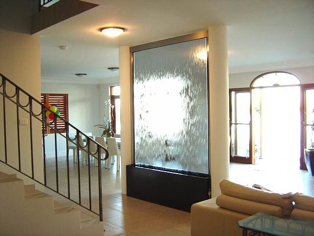 A glass water wall in a living room.