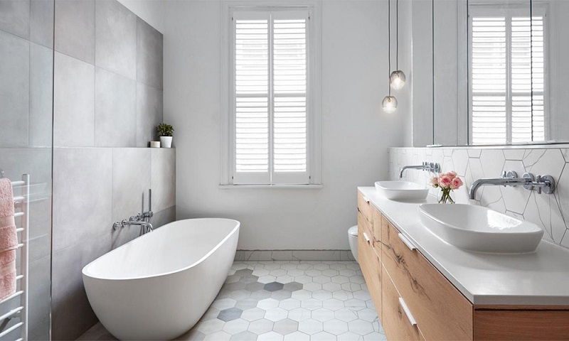 A modern bathroom with a white tub and sink for home projects.