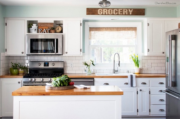 Remodeling ideas for a kitchen with white cabinets and a wooden counter top.