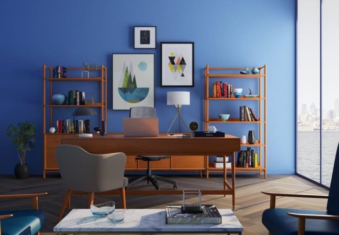 A small home office with blue walls and furniture.
